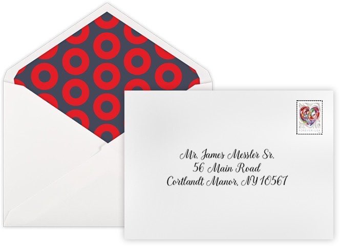 White wedding envelope with a red and navy patterned liner, beside an envelope with the guest address printed in script